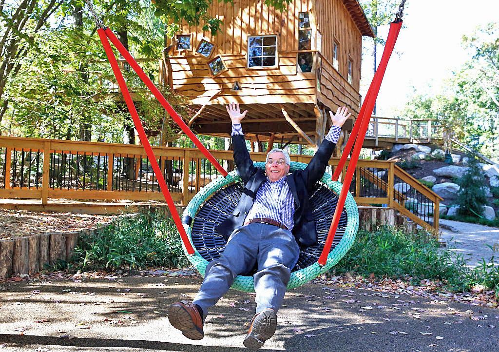 enthusiastic man laying in nest swing, arms and legs akimbo